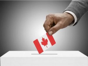 man-dropping-canada-flag-voting-ticket-into-white-box