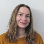 Sasha Lisovsky, BoD, Brain injury Canada. Woman with long blonde hair in a mustard yellow sweater smiling at the camera.